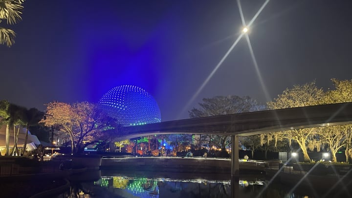 EPCOT'S Spaceship Earth glows blue under a full moon. Image courtesy Brian Miller