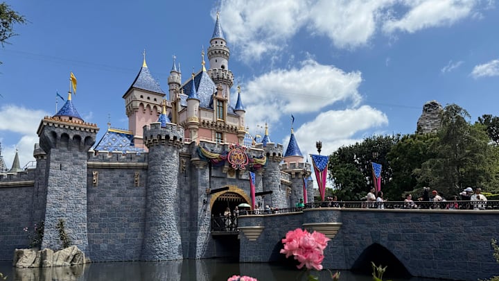 Sleeping Beauty Castle is adorned with Disneyland 70th anniversary flourishes.