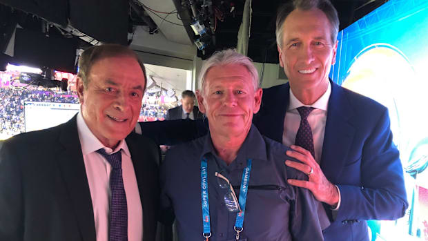 Spotter Kelly Hayes stands with Al Michaels (left) and Chris Collinsworth (right) ahead of a broadcast.