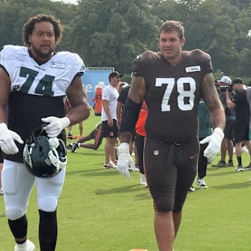 Offensive tackles Kendall Lamm of the Eagles (74) and Jack Conkin of the Browns head to a drill during their practice on Aug. 13, 2025.