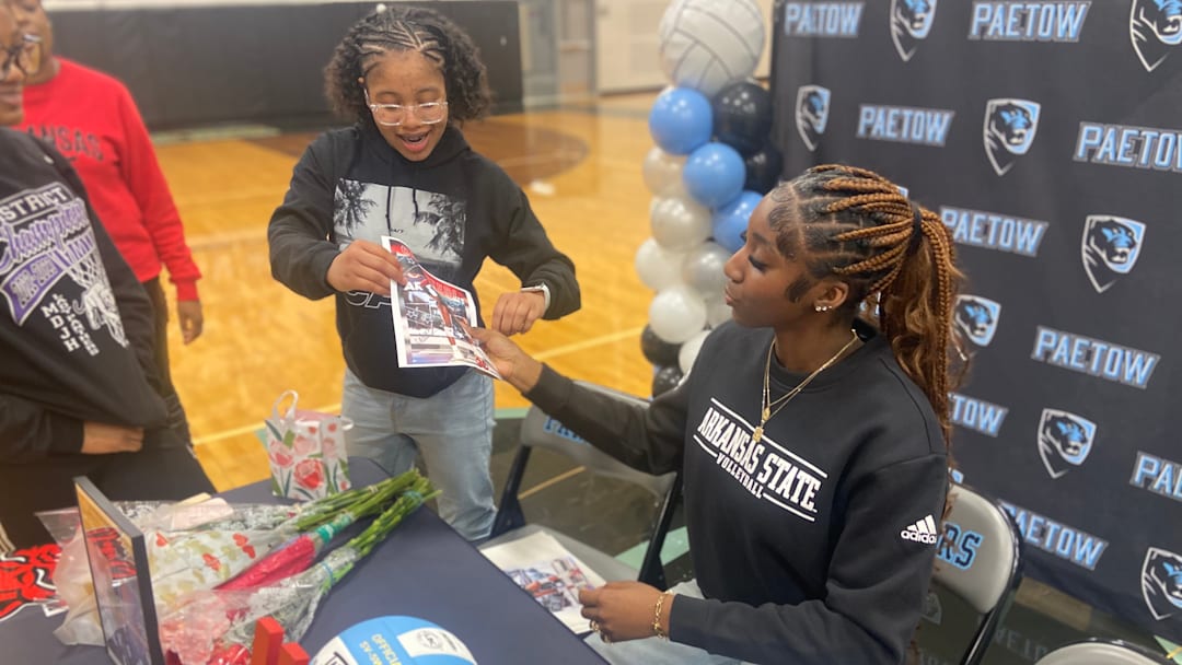 Paetow junior middle hitter Calea Bush, sitting, signs autographs after verbally committing to continue her volleyball career at Arkansas State on Feb. 13 at Paetow High. Bush is the first volleyball player from Paetow to receive a NCAA Division I scholarship.