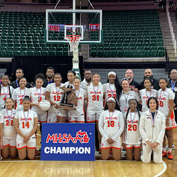 The Belleville Tigers pose for a picture after winning the Division 1 MHSAA girls basketball state championship on Saturday, March 22, 2025, at the Breslin Center in East Lansing, Michigan.