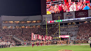 FSU's cheerleaders and football team sprint onto the field at Doak Campbell Stadium for Saturday's showdown against Miami.