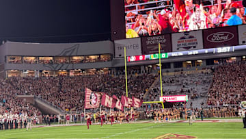 FSU's cheerleaders and football team sprint onto the field at Doak Campbell Stadium for Saturday's showdown against Miami.