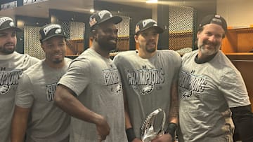 Eagles linebackers - left to right: Ben Van Sumeren, Jeremiah Trotter, Jr., Oren Burks, Zack Baun, and position coach Bobby King - pose with the NFC trophy after beating the Washington Commanders in the conference title game.