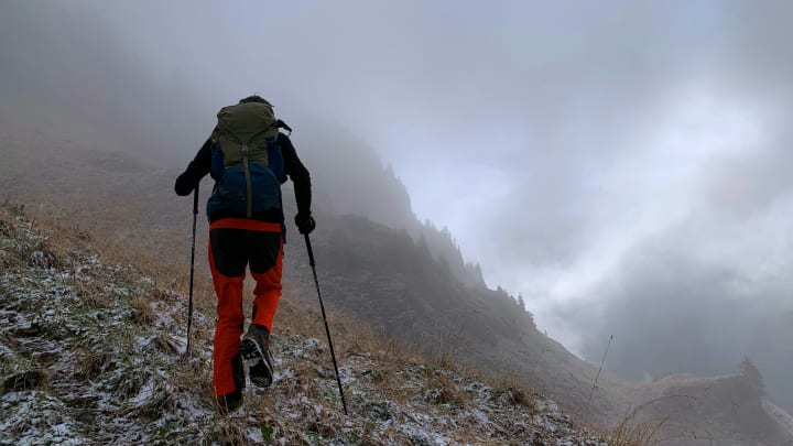 Trail athlete using trekking poles while hiking