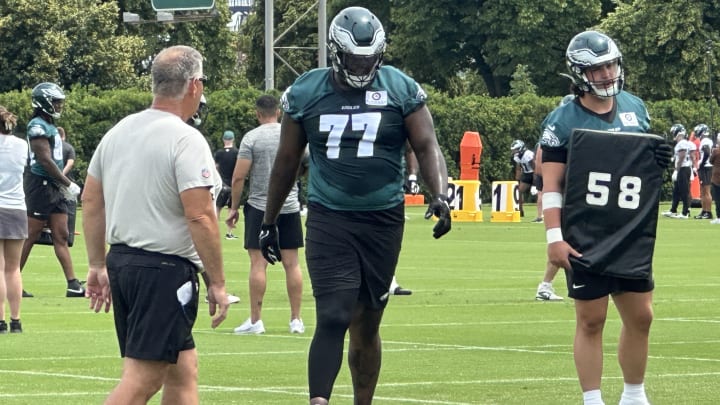 Mekhi Becton (No. 77) gets some technique tips from line coach Jeff Stoutland as Becton transitions to from tackle to guard.