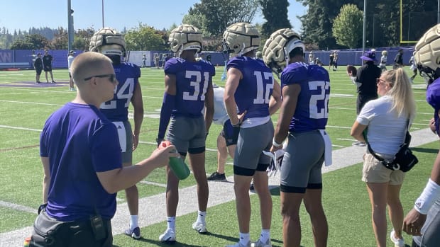 UW safeties Makell Esteen (24), Paul Mencke Jr. (31). Tristan Dunn (12) and Peyton Waters (22) wait in line during a drill.