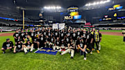 The Brewers celebrate with an 'L' flag on the field after beating the Cubs, 3 games to 2, in the 2025 National League Division Series