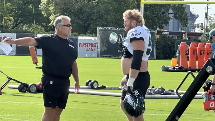 Offensive line coach Jeff Stoutland (left) gives center Cam Jurgens direction during a drill at Eagles training camp.