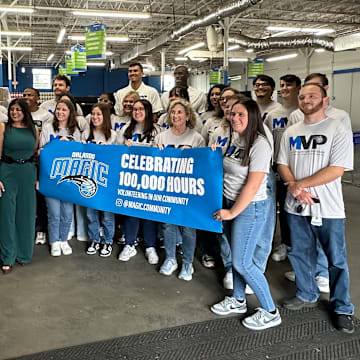 Orlando Magic rookie Tristan da Silva, community ambassador Bo Outlaw and Magic staffers with the Magic Volunteer Program celebrate 100,000 hours of community service hours given to the Central Florida community during a service project at United Against Poverty in Orlando.