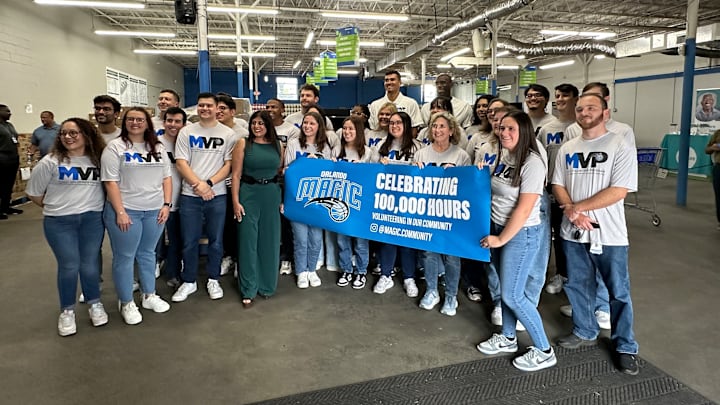 Orlando Magic rookie Tristan da Silva, community ambassador Bo Outlaw and Magic staffers with the Magic Volunteer Program celebrate 100,000 hours of community service hours given to the Central Florida community during a service project at United Against Poverty in Orlando.