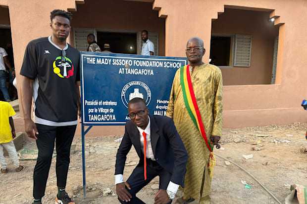 Mady Sissoko poses in front of the school he funded