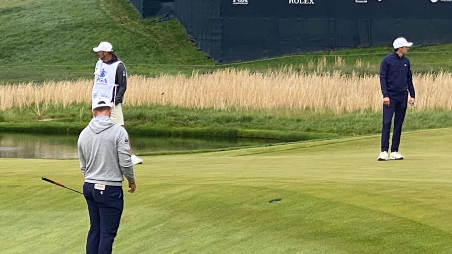 Jon Rahm investigates the slope into the green at the PGA Championship.