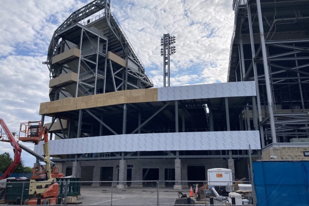 Construction cranes and equipment sit outside a gate at Penn State's Beaver Stadium.