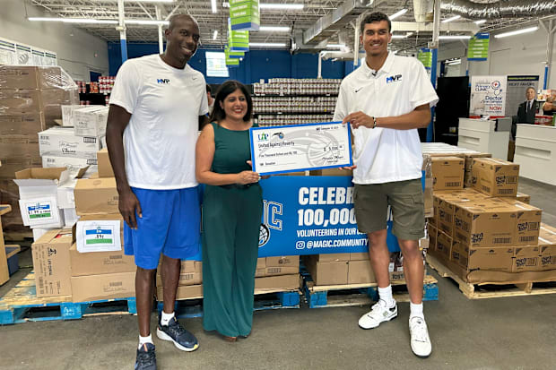 Bo Outlaw and Tristan da Silva of the Orlando Magic present United Against Poverty with a $5,000 check.