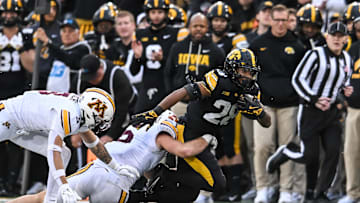 Oct 25, 2025; Iowa City, Iowa, USA; Iowa Hawkeyes running back Kamari Moulton (28) is tackled by Minnesota Golden Gophers linebacker Maverick Baranowski (6) and defensive back Koi Perich (3) during the fourth quarter at Kinnick Stadium. Mandatory Credit: Jeffrey Becker-Imagn Images