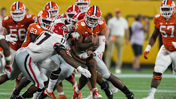 Clemson Tigers quarterback D.J. Uiagalelei (5) is tackled by Georgia Bulldogs linebacker Nakobe Dean (17) 