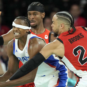 Aug 6, 2024; Paris, France; France point guard Frank Ntilikina (1) fights to control the ball against Canada guard Shai Gilgeous-Alexander (2) and small forward Dillon Brooks (24) in the second quarter in a men’s basketball quarterfinal game during the Paris 2024 Olympic Summer Games at Accor Arena.