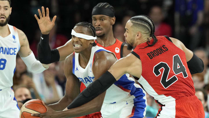 Aug 6, 2024; Paris, France; France point guard Frank Ntilikina (1) fights to control the ball against Canada guard Shai Gilgeous-Alexander (2) and small forward Dillon Brooks (24) in the second quarter in a men’s basketball quarterfinal game during the Paris 2024 Olympic Summer Games at Accor Arena.