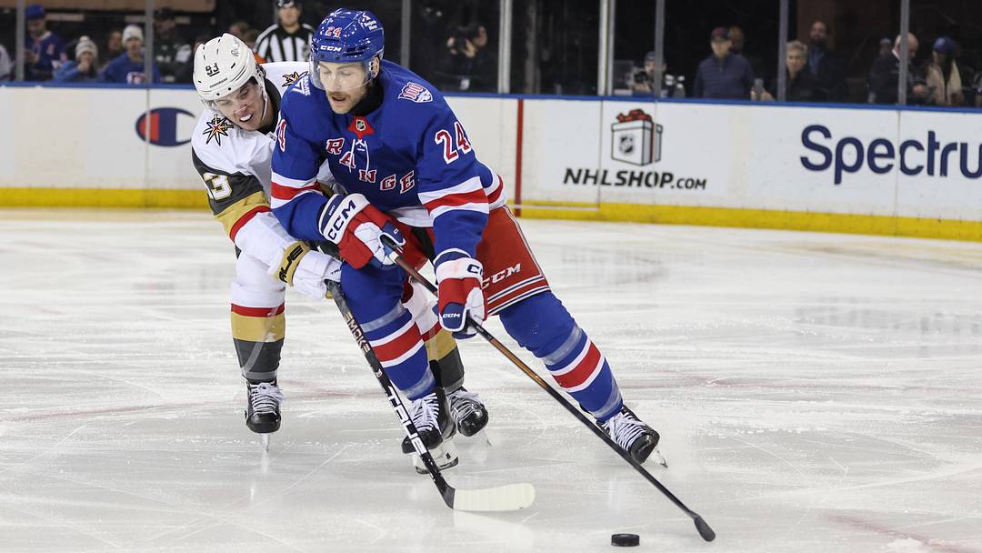 Dec 7, 2025; New York, New York, USA;  Vegas Golden Knights right wing Mitch Marner (93) and New York Rangers defenseman Carson Soucy (24) battle for control of the puck in the second period at Madison Square Garden. Mandatory Credit: Wendell Cruz-Imagn Images