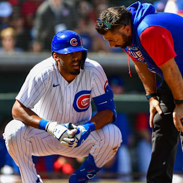 Mar 21, 2022; Mesa, Arizona, USA; Chicago Cubs right field Brennen Davis talks to a trainer after being hit by a pitch in the second inning against the Cincinnati Reds during spring training at Sloan Park