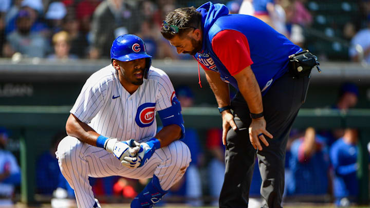 Mar 21, 2022; Mesa, Arizona, USA; Chicago Cubs right field Brennen Davis talks to a trainer after being hit by a pitch in the second inning against the Cincinnati Reds during spring training at Sloan Park