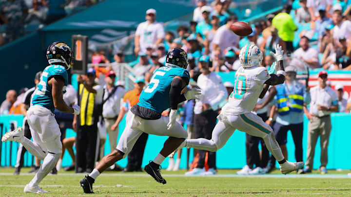 Sep 8, 2024; Miami Gardens, Florida, USA; Miami Dolphins wide receiver Tyreek Hill (10) catches the football ahead of Jacksonville Jaguars safety Andre Cisco (5) and cornerback Ronald Darby (25) during the third quarter at Hard Rock Stadium. Mandatory Credit: Sam Navarro-Imagn Images