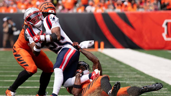 Cincinnati Bengals wide receiver Ja'Marr Chase (1) and Cincinnati Bengals halfback Zack Moss (31) tackle New England Patriots corner back Marcus Jones (25) as he returns an interception in the second quarter of the NFL game at Paycor Stadium in Cincinnati on Sunday, Sept. 8, 2024.