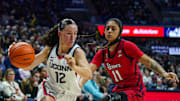 Feb 12, 2025; Storrs, Connecticut, USA; UConn Huskies guard Ashlynn Shade (12) drives the ball against St. John's Red Storm forward Janeya Grant (11) in the first half at Harry A. Gampel Pavilion. Mandatory Credit: David Butler II-Imagn Images