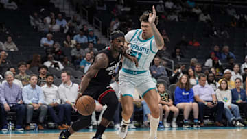 Oct 8, 2024; Charlotte, North Carolina, USA; Miami Heat forward Jimmy Butler (22) drives to the basket defended by Charlotte Hornets guard LaMelo Ball (1) during the second quarter at Spectrum Center. Mandatory Credit: Jim Dedmon-Imagn Images