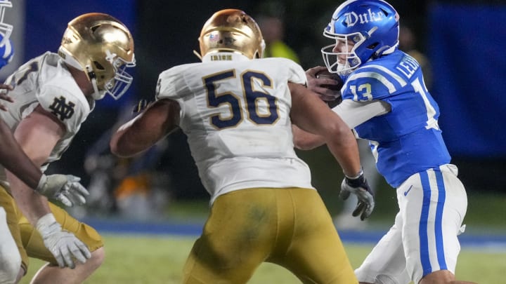 Sep 30, 2023; Durham, North Carolina, USA; Duke Blue Devils quarterback Riley Leonard (13) tries to elude Notre Dame Fighting Irish defensive lineman Howard Cross III (56) during the second half at Wallace Wade Stadium.