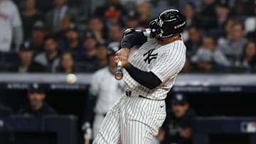Oct 2, 2025; Bronx, New York, USA; New York Yankees outfielder Trent Grisham (12) hits a single in the third inning against the Boston Red Sox during game three of the Wildcard round for the 2025 MLB playoffs at Yankee Stadium. Mandatory Credit: Vincent Carchietta-Imagn Images
