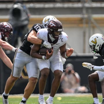 Aug 31, 2024; Nashville, Tennessee, USA;  Virginia Tech Hokies quarterback Kyron Drones (1) gets tackled from behind by Vanderbilt Commodores linebacker Langston Patterson (10) during the second half at FirstBank Stadium. Mandatory Credit: Steve Roberts-Imagn Images