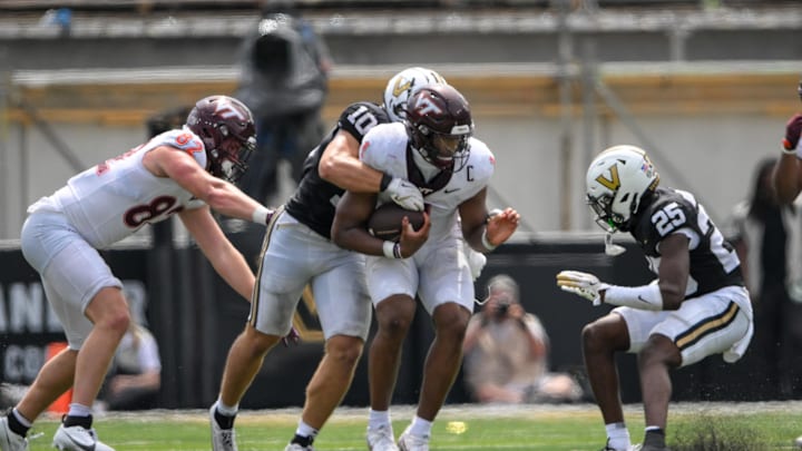 Aug 31, 2024; Nashville, Tennessee, USA;  Virginia Tech Hokies quarterback Kyron Drones (1) gets tackled from behind by Vanderbilt Commodores linebacker Langston Patterson (10) during the second half at FirstBank Stadium. Mandatory Credit: Steve Roberts-Imagn Images