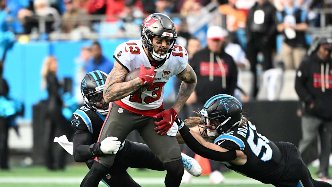 Dec 21, 2025; Charlotte, North Carolina, USA;  Tampa Bay Buccaneers wide receiver Mike Evans (13) with the ball as Carolina Panthers safety Nick Scott (21) and linebacker Christian Rozeboom (56) defend in the fourth quarter at Bank of America Stadium. Mandatory Credit: Bob Donnan-Imagn Images