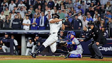 Oct 30, 2024; New York, New York, USA; New York Yankees designated hitter Giancarlo Stanton (27) hits an RBI sacrifice fly during the sixth inning against the Los Angeles Dodgers in game four of the 2024 MLB World Series at Yankee Stadium.