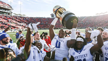 Kentucky Wildcats defensive lineman Deone Walker (0) holds up the Governor's Cup after the Wildcats beat Louisville 38-31 Saturday. Nov. 24, 2023