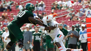 Sep 28, 2013; Tampa, FL, USA;Miami Hurricanes linebacker Tyriq McCord (17) rushes past South Florida Bulls offensive linesman Quinterrius Eatmon (70)  during the second half at Raymond James Stadium. Miami Hurricanes defeated the South Florida Bulls 49-21. Mandatory Credit: Kim Klement-Imagn Images