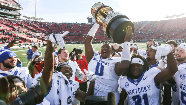 Kentucky Wildcats defensive lineman Deone Walker (0) holds up the Governor's Cup after the Wildcats beat Louisville 38-31 Saturday. Nov. 24, 2023