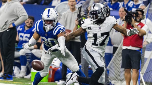 Colts safety Nick Cross (blue jersey with white helmet & pants) knocks the football away from an opponent's receiver. 