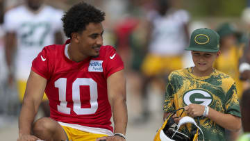 July 26, 2023; Green Bay, WI, USA; Green Bay Packers quarterback Jordan Love (10) talks with a young fan while riding a bicycle from Lambeau Field to practice on the first day of training camp at training camp at Ray Nitschke Field. Mandatory credit: Tork Mason USA TODAY NETWORK-Wisconsin
