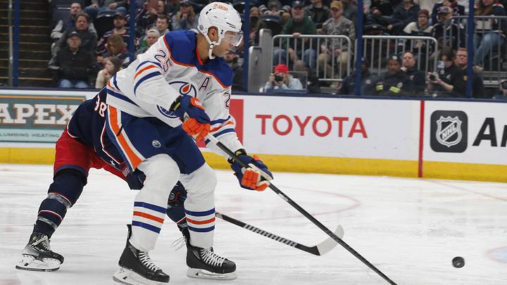 Mar 7, 2024; Columbus, Ohio, USA; Edmonton Oilers defenseman Darnell Nurse (25) tips the put on goal as Columbus Blue Jackets center Boone Jenner (38) trails the play during the third period at Nationwide Arena. Mandatory Credit: Russell LaBounty-Imagn Images