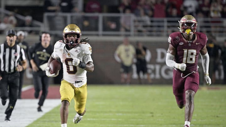 Boston College Eagles running back Treshaun Ward runs the ball down the field past Florida State Seminoles linebacker Cam Riley.