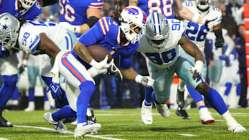 Dec 17, 2023; Orchard Park, New York, USA; Buffalo Bills running back James Cook (4) is tackled by Dallas Cowboys defensive end DeMarcus Lawrence (90) in the first half at Highmark Stadium. Mandatory Credit: Gregory Fisher-Imagn Images