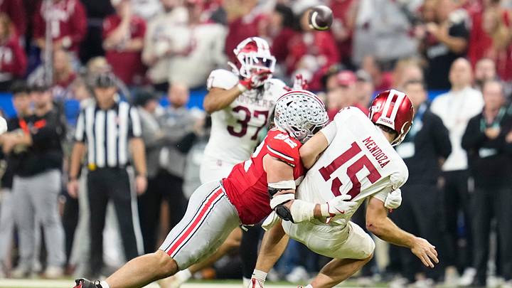 Indiana Hoosiers quarterback Fernando Mendoza (15) gets off a pass as he's hit by Ohio State Buckeyes defensive end Caden Curry (92) during the first half of the Big Ten Conference championship game at Lucas Oil Stadium in Indianapolis on Dec. 6, 2025.
