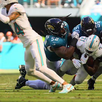 Sep 8, 2024; Miami Gardens, Florida, USA; Miami Dolphins running back Raheem Mostert (31) runs with the football against Jacksonville Jaguars defensive tackle DaVon Hamilton (52), linebacker Yasir Abdullah (56) and cornerback Montaric Brown (30) during the fourth quarter at Hard Rock Stadium. Mandatory Credit: Sam Navarro-Imagn Images