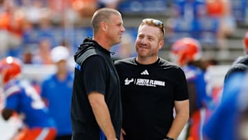Sep 6, 2025; Gainesville, Florida, USA; Florida Gators head coach Billy Napier and South Florida Bulls head coach Alex Golesh talk before the game at Ben Hill Griffin Stadium. Mandatory Credit: Matt Pendleton-Imagn Images