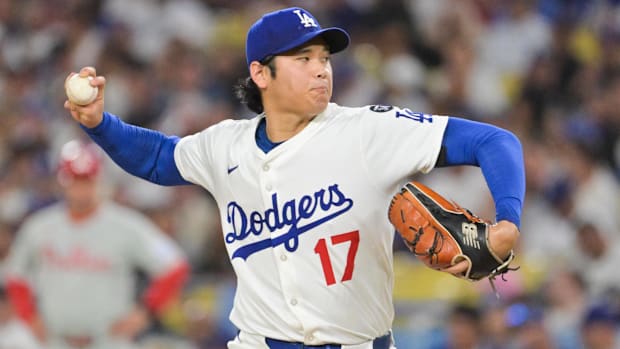Los Angeles Dodgers two-way player Shohei Ohtani (17) delivers a pitch in a white uniform and blue hat