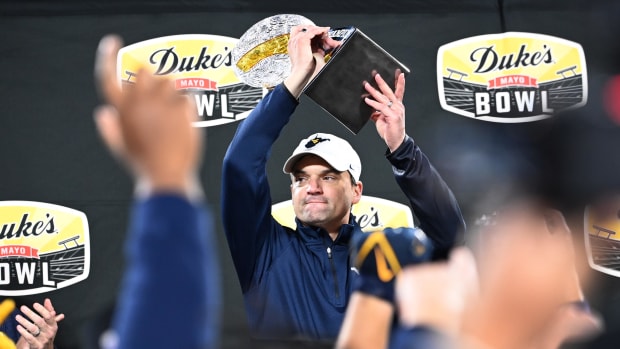 West Virginia Mountaineers head coach Neal Brown holds up the championship trophy. Bob Donnan-USA TODAY Sports